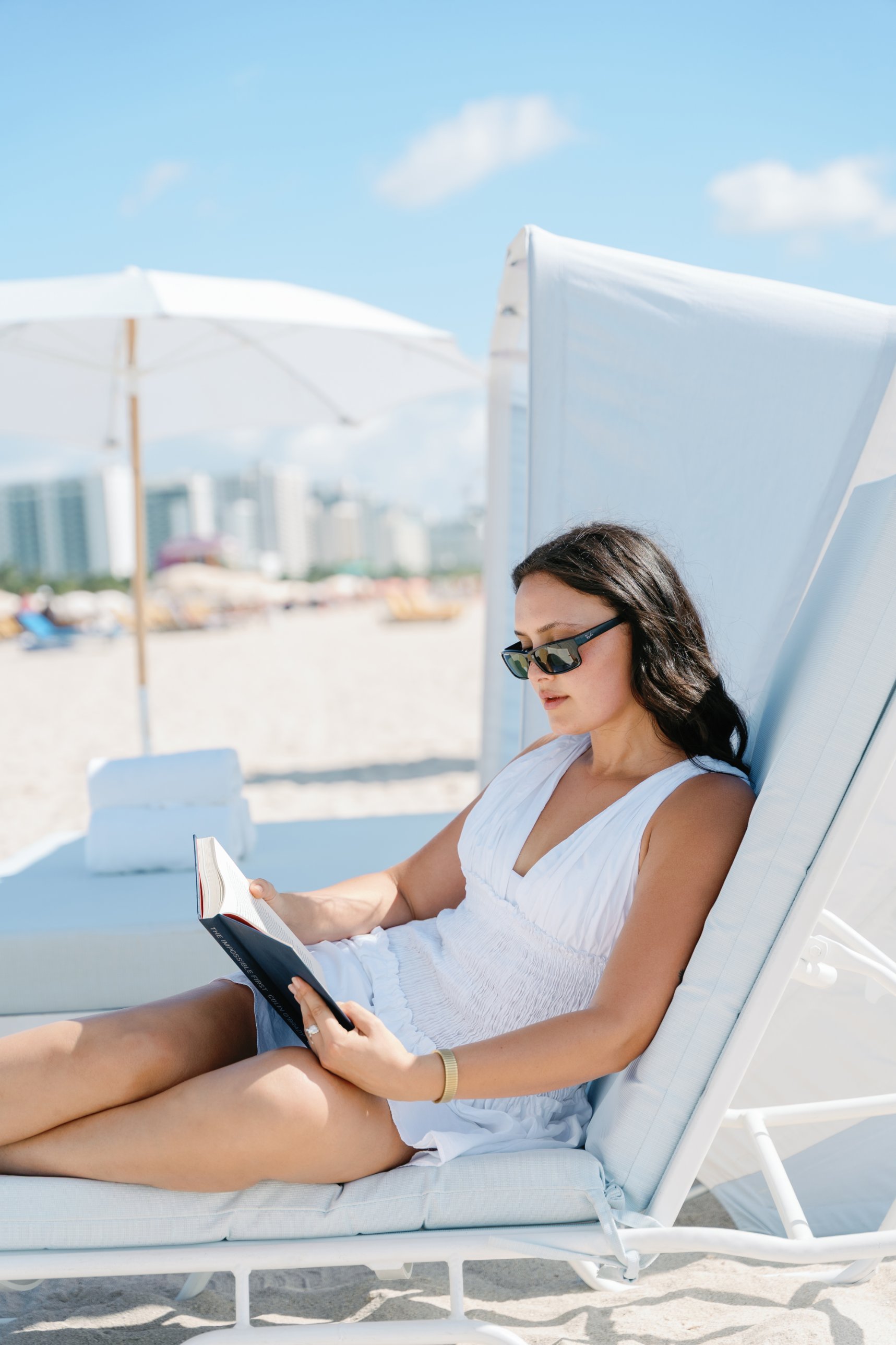 Guest reading on a lounge chair with the Miami Beach skyline behind
